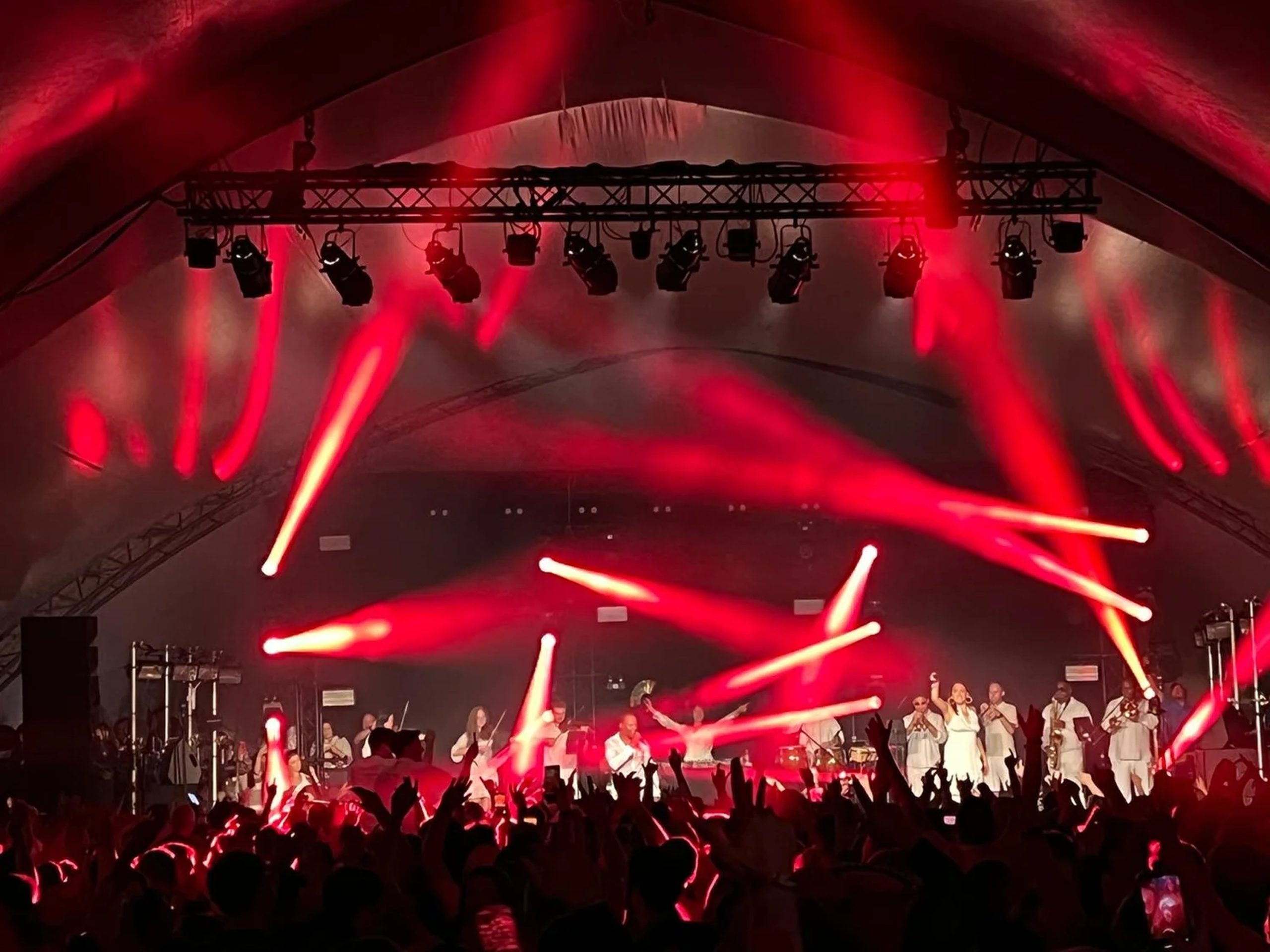 Bangers & Anthems — Festival Performance with Full Audience Urban Soul Orchestra performing on a large festival stage in red lighting with a crowd of thousands with hands raised.