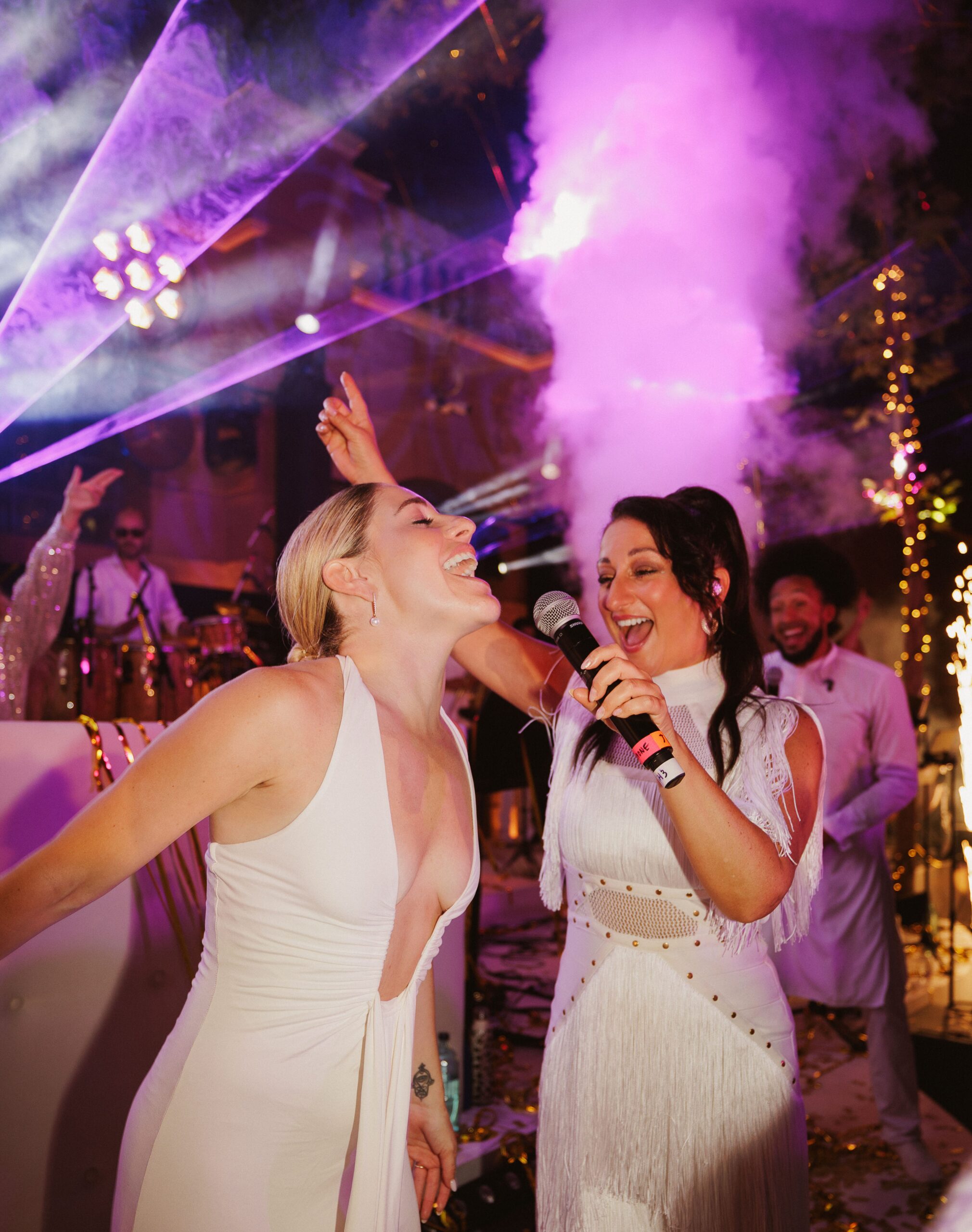 Wedding Evening Party — Vocalist Performing with the Bride An Urban Soul Orchestra vocalist singing into a microphone alongside the bride on the dancefloor at an evening wedding party.